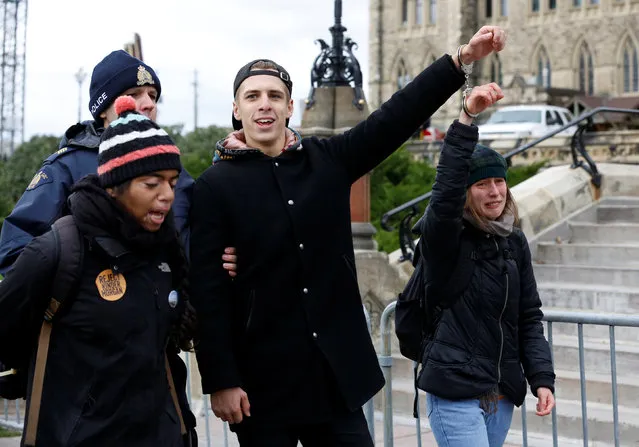 Protestors are detained after crossing a police barricade during a demonstration against the proposed Kinder Morgan pipeline on Parliament Hill in Ottawa, Ontario, Canada, October 24, 2016. (Photo by Chris Wattie/Reuters)