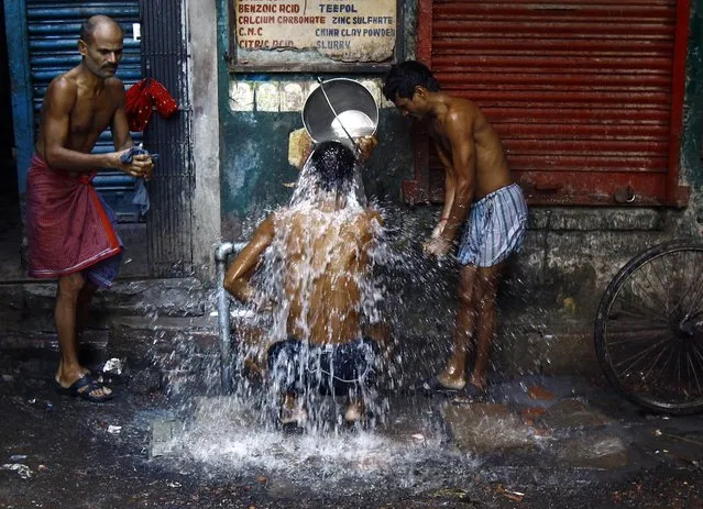 Men bathe at a roadside municipal tap in Kolkata January 5, 2015. (Photo by Rupak De Chowdhuri/Reuters)