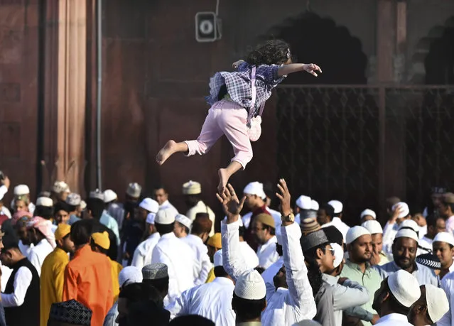 A person plays with his daughter after offering Eid al-Fitr prayer marking the end of the holy fasting month of Ramadan at the Jama Masjid, in New Delhi, India, Saturday, April 22, 2023. (Photo by Deepanshu Aggarwal/AP Photo)