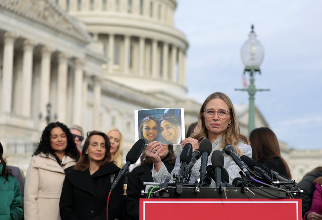 Epstein abuse survivor Annie Farmer holds up a photo of her younger self with her sister Maria Farmer during a news conference with lawmakers on the Epstein Files Transparency Act outside the U.S. Capitol on November 18, 2025 in Washington, DC. The House is expected to vote today on the legislation, which instructs the U.S. Department of Justice to release all files related to the late accused s*x trafficker Jeffrey Epstein. (Photo by Heather Diehl/Getty Images)