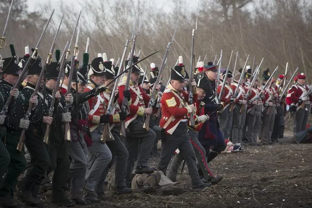 Reenactors playing the roll of British soldiers march towards United States fighters during a reenactment of the Battle of New Orleans in the War of 1812, marking its  bicentennial  in Chalmette, Louisiana January 10, 2015. (Photo by Lee Celano/Reuters)