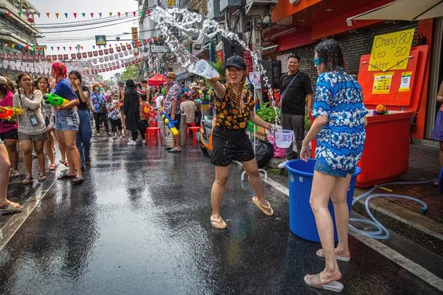 Thai people throw buckets of water on revelers on Khaosan Road on April 13, 2023 in Bangkok, Thailand. (Photo by Lauren DeCicca/Getty Images)