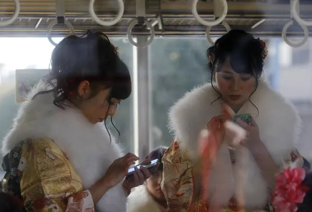 Japanese women in kimonos use smart phones inside a train after a Coming of Age Day celebration ceremony at an amusement park in Tokyo January 12, 2015. (Photo by Yuya Shino/Reuters)