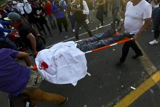 A dead demonstrator who was shot in the head is carried by paramedics after clashes erupted during a march against Nicaragua's President Daniel Ortega in Managua, Nicaragua, Wednesday, May 30, 2018. (Photo by Esteban Felix/AP Photo)