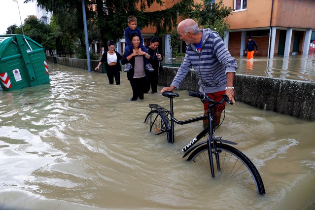 People wade through a flooded street, as the Emilia-Romagna region experiences floods triggered by severe weather, in Lugo, Emilia-Romagna, Italy, on September 20, 2024. (Photo by Ciro de Luca/Reuters)