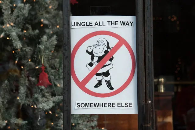 A sign in the window of a bar prohibits Santas during the annual SantaCon pub crawl December 12, 2015 in the Brooklyn borough of New York City. (Photo by Stephanie Keith/Getty Images)