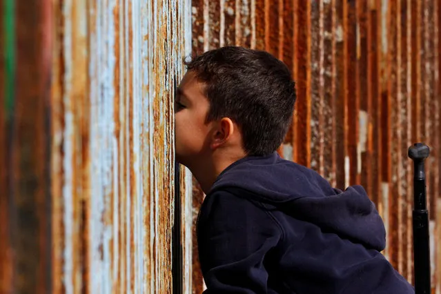 A boy talks to his relatives across a fence separating Mexico and the United States, in Tijuana, Mexico, November 12, 2016. (Photo by Jorge Duenes/Reuters)