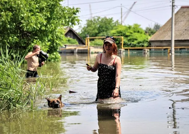 Local residents walk in a flooded street during an evacuation from a flooded area after the Nova Kakhovka dam breached, amid Russia's attack on Ukraine, in Kherson, Ukraine on June 7, 2023. (Photo by Ivan Antypenko/Reuters)