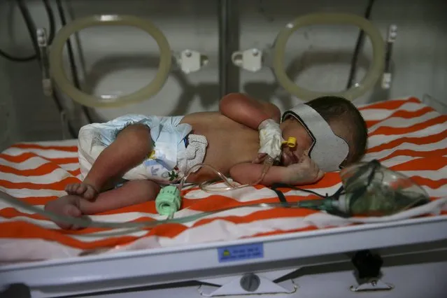 A baby lies inside a neonatal unit in a field hospital in the Douma neighborhood of Damascus, Syria December 8, 2015. The baby was born after a cesarean surgery after his mother died from shelling by what activists said was forces loyal to Syria's president Bashar al-Assad in the Douma neighborhood of Damascus, Syria. (Photo by Bassam Khabieh/Reuters)