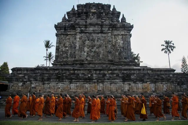Buddhist monks walk around Mendut temple during the practice of Pradakshina ahead of Vesak Day in Magelang, Central Java, Indonesia on May 28, 2018. (Photo by Hendra Nurdiyansyah/Reuters/Antara Foto)