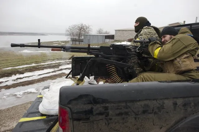 Ukrainian servicemen fire a machine gun in the village near Mariupol, a city on the Sea of Azov, January 26, 2015. (Photo by Maksim Levin/Reuters)