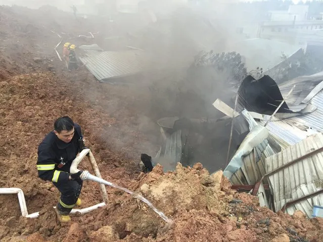Rescuers spray liquid next to damaged sheds at the site of a landslide at an industrial park in Shenzhen, Guangdong province, China, December 20, 2015. (Photo by Reuters/Stringer)