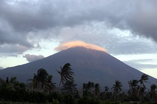 Mount Agung volcano is seen at sunrise in Karangasem, Bali, Indonesia, Tuesday, October 3, 2017. Dire warnings that the volcano on the Indonesian tourist island of Bali will erupt have caused tens of thousands to flee. (Photo by Firdia Lisnawati/AP Photo)