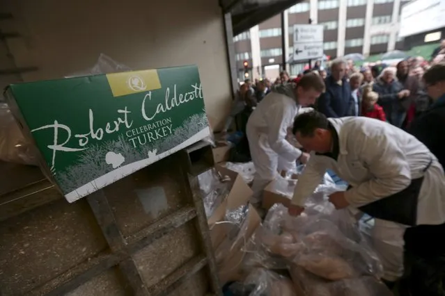 Butchers open boxes of turkey as they sell their remaining produce of the year at discounted prices during the traditional Christmas Eve auction at Smithfield's market in London December 24, 2015. (Photo by Neil Hall/Reuters)