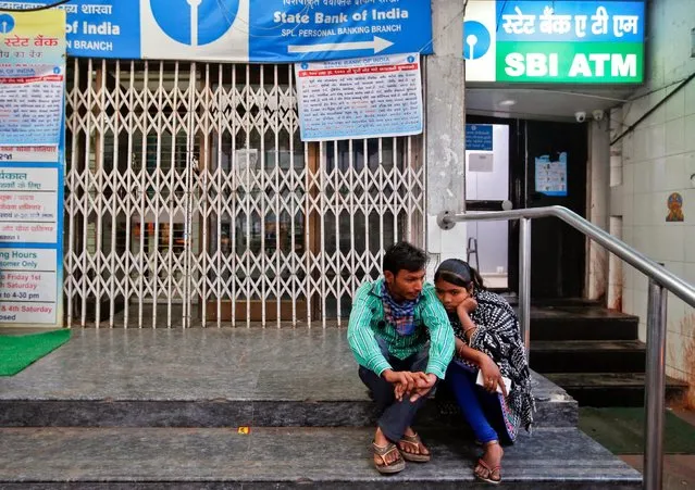 A couple waits for a bank to open to deposit or exchange their old high denomination banknotes in the early hours in Ahmedabad, India, November 16, 2016. (Photo by Amit Dave/Reuters)