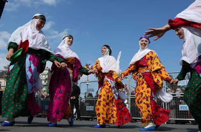 Women wearing traditional dresses dance during a rally to mark International Women's Day in Diyarbakir, Turkey on March 8, 2021. (Photo by Sertac Kayar/Reuters)