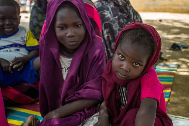 Girls sit outside at a camp for the internally displaced in al-Suwar, about 15 kilometres north of Wad Madani, on June 22, 2023. The fighting in Sudan between the regular army, led by Abdel Fattah al-Burhan, and the paramilitary Rapid Support Forces (RSF), headed by his former deputy Mohamed Hamdan Daglo, has claimed more than 2,000 lives since April 15. The latest in a series of ceasefires that have all been systematically violated ended early on June 21, and fighting resumed within minutes. (Photo by AFP Photo/Stringer)