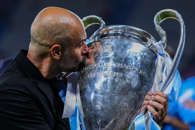 Manchester City's head coach Pep Guardiola kisses the trophy after winning the Champions League final soccer match between Manchester City and Inter Milan at the Ataturk Olympic Stadium in Istanbul, Turkey, Sunday, June 11, 2023. Manchester City won 1-0. (Photo by Manu Fernandez/AP Photo)
