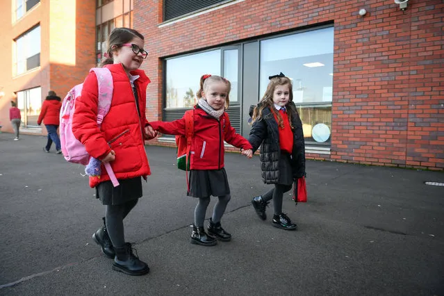 Pupils arrive at Clyde Primary School in Glasgow on February 22, 2021 as schools in Scotland started to reopen to more of the youngest students in an easing of the coronavirus shutdown. (Photo by Andy Buchanan/AFP Photo)