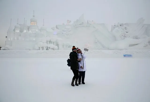 Visitors take a selfie in front of a snow sculpture at the Harbin International Ice and Snow Festival, in Harbin, China, January 5, 2016. (Photo by Wu Hong/EPA)