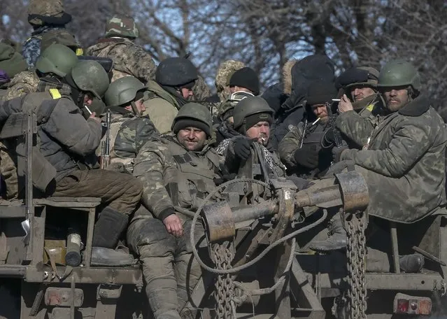 Ukrainian servicemen ride on a military vehicle as they leave an area around Debaltseve, eastern Ukraine near Artemivsk February 18, 2015. (Photo by Gleb Garanich/Reuters)