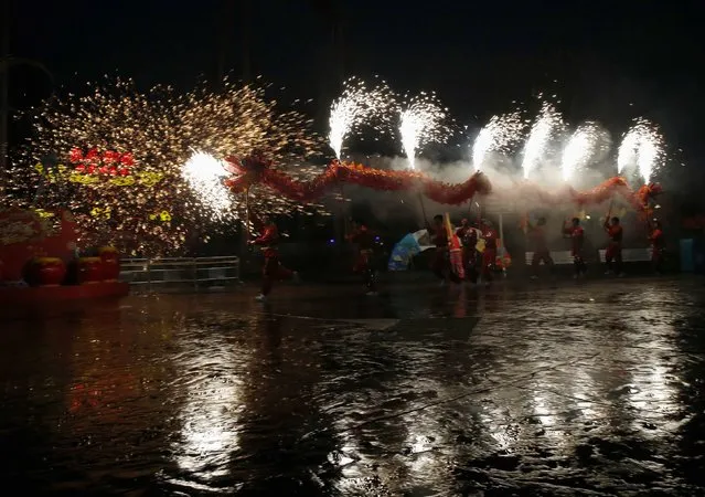 Dancers perform a fire dragon dance in the shower of molten iron spewing firework-like sparks during a folk art performance to celebrate traditional Chinese Spring Festival on Chinese Lunar New Year at the Happy Valley amusement park in Beijing February 19, 2015. (Photo by Kim Kyung-Hoon/Reuters)