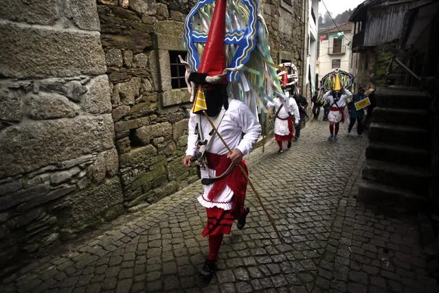 In this photo taken on Saturday, Feb. 14, 2015 revellers dressed in Carnival traditional costumes dance and jump as they parade during Carnival festivities in Lazarim, northeastern Portugal. (AP Photo/Francisco Seco)