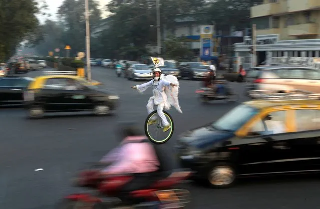 Ibrahim Khan rides a unicycle as he tours the city to create awareness about dangers posed to birds during kite flying, a popular way to mark Makkar Sankranti festival, in Mumbai, India, Tuesday, January 12, 2021. Makar Sankranti will be celebrated across the country on Jan. 14. (Photo by Rajanish Kakade/AP Photo)