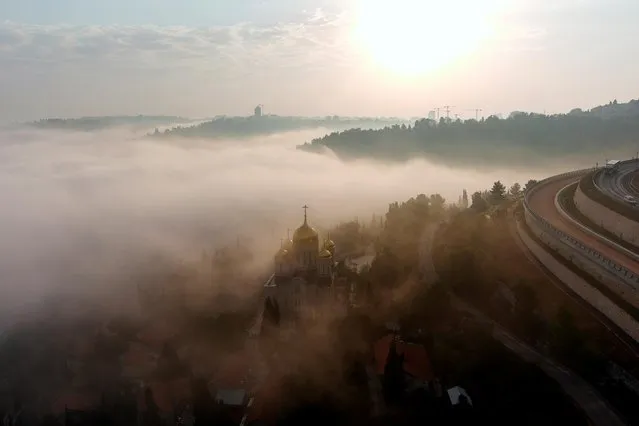 An aerial view shows early morning fog rolling over the Cathedral of All Russian Saints in the grounds of the Russian Orthodox Gorny Convent in Ein Kerem, Jerusalem, September 10, 2020. (Photo by Ilan Rosenberg/Reuters)