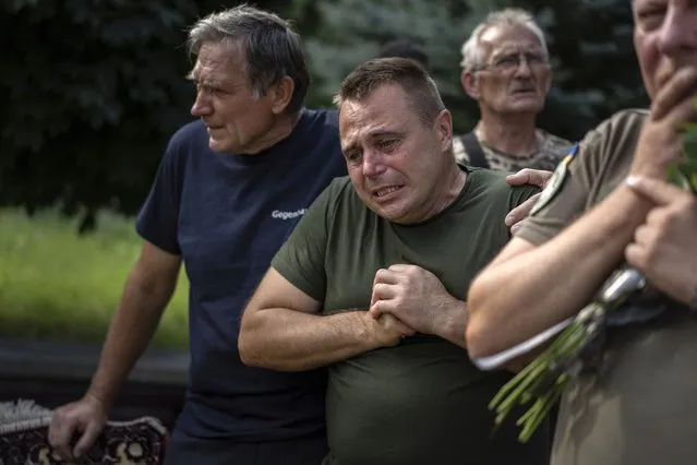 A Ukrainian serviceman reacts as he bids his last farewell to the fallen Ukrainian pilots and crew members of mi-8 military helicopters Volodymyr Rumar, Ivan Yaroviy, Yuriy Anisimov, Valentyn Vorobets, Victor Opanasiuk during a farewell ceremony in Poltava, Ukraine, Friday, September 1, 2023. (Photo by Evgeniy Maloletka/AP Photo)