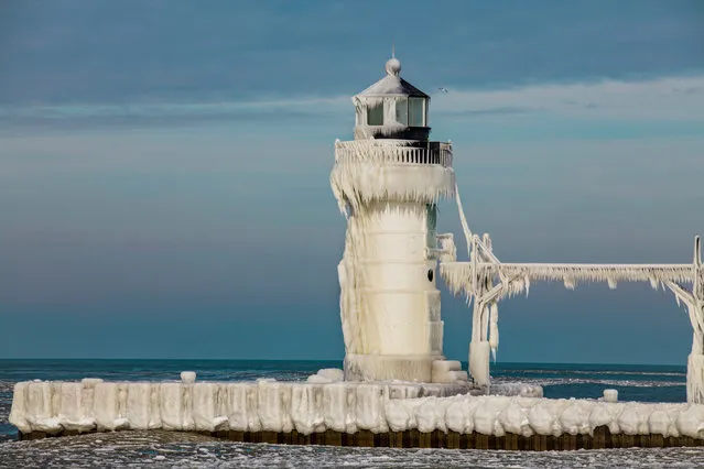 The St Joseph North Pier lighthouse is coated in frost from recent storms. (Photo by Mike Kline/Barcroft Media)
