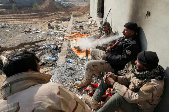 Members of the Iraqi Army smoke waterpipe as they rest during clashes with Islamic State militants at the south of Mosul, Iraq December 12, 2016. (Photo by Ammar Awad/Reuters)