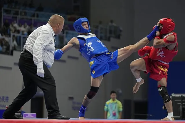 China's Feng He, in blue, fights Iran's Mohsen Mohammadseifi in the Wushu men's 70kg final at 19th Asian Games in Hangzhou, China, Thursday, September 28, 2023. (Photo by Aijaz Rahi/AP Photo)