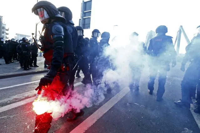 A policeman holds a flare during a protest of members of “Blockupy” anti-capitalist movement near the European Central Bank (ECB) building before the official opening of its new headquarters in Frankfurt March 18, 2015. (Photo by Ralph Orlowski/Reuters)