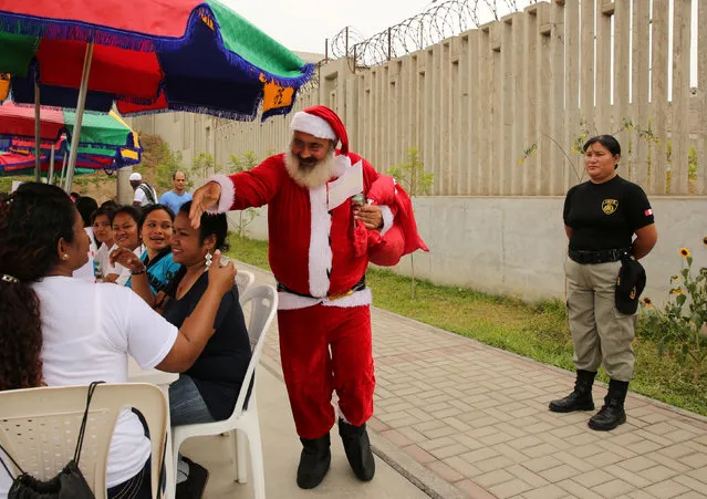 Prisoner Jose Luis Pereira from Extremadura, Spain, dressed as Santa Claus, greets other prisoners during a Christmas celebration for international inmates at Ancon prison in Callao, Peru, December 22, 2016. (Photo by Mariana Bazo/Reuters)