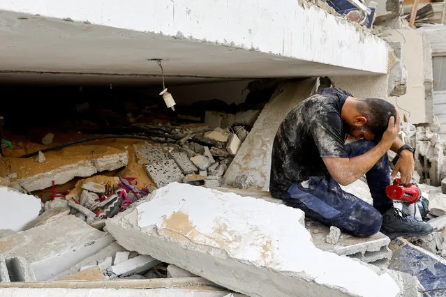 A rescuer reacts as he works with others to remove Palestinian casualties from under the rubble of a house destroyed in Israeli strikes, in Rafah in the southern Gaza Strip on October 9, 2023. (Photo by Ibraheem Abu Mustafa/Reuters)