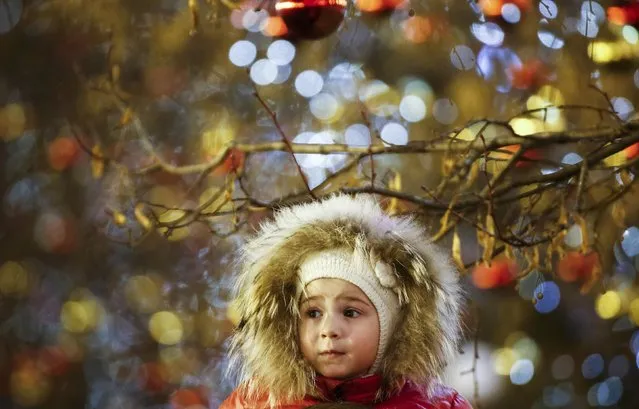 A girl stands under a tree decorated for the New Year and Christmas season at Red Square in Moscow, Russia December 17, 2016. (Photo by Maxim Shemetov/Reuters)