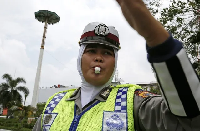 An Acehnese female police officer wear a hijab on duty in the street in Banda Aceh, Indonesia, 27 March 2015. (Photo by Hotli Simanjuntak/EPA)