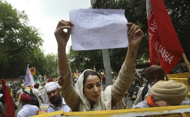 A woman farmer holds a banner during a protest in New Delhi, India, Thursday, July 22, 2021. More than 200 farmers on Thursday began a protest near India's Parliament to mark eight months of their agitation against new agricultural laws that they say will devastate their income. (Photo by Manish Swarup/AP Photo)