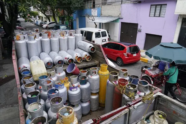 Empty LP gas cylinders are stacked on a delivery truck in Mexico City, Wednesday, August 4, 2021. Crews that distribute LP gas in Mexico’s capital went on strike Tuesday after the government imposed price controls on the fuel that most Mexicans use to cook and heat water. (Photo by Eduardo Verdugo/AP Photo)