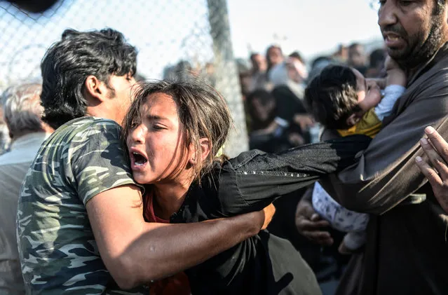 A handout image provided by the World Press Photo (WPP) organization on 18 February 2016 shows a picture by Turkish photographer Bulent Kilic that won Third Prize Stories in the Spot News Category of the 59th annual World Press Photo Contest, it was announced by the WPP Foundation in Amsterdam, The Netherlands on 18 February 2016. The picture shows Syrians fleeing the war rushing through broken down border fences to enter Turkish territory illegally, near the Turkish border crossing at Akcakale in Sanliurfa province on June 14, 2015. (Photo by Bulent Kilic/World Press Photo Contest/EPA)