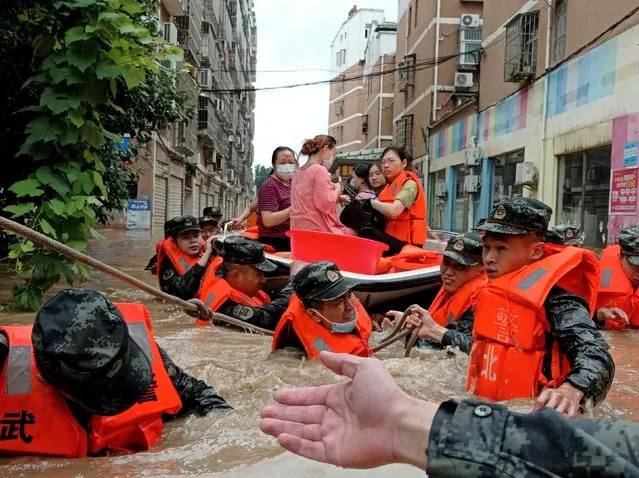 Armed police use boat to evacuate residents trapped in floodwater as heavy rain hits central China on August 12, 2021 in Suizhou, Hebei Province of China. (Photo by Xie Ding'an/VCG via Getty Images)