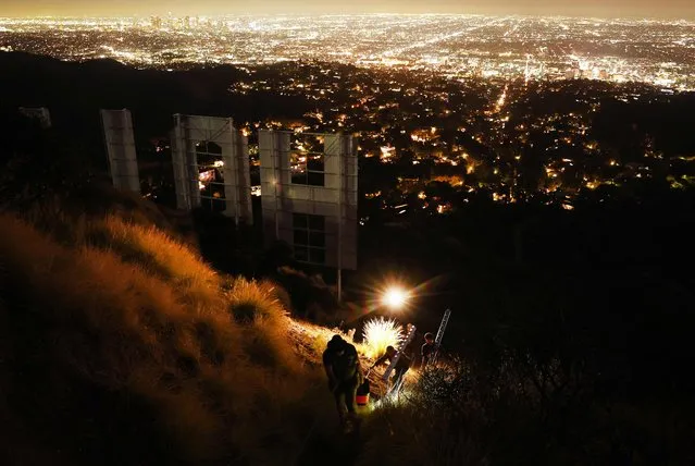 Equipment is carried away from the historic Hollywood sign on the 100th birthday of the iconic sign first being illuminated on December 8, 2023 in Los Angeles, California. The Hollywood Sign Trust has been honoring the sign's centennial year and held a special anniversary celebration marking the day in 1923 when the sign was first lit with 4,000 20-watt bulbs. (Photo by Mario Tama/Getty Images/AFP Photo)