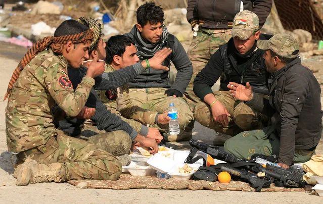 Iraqi rapid response forces eat food during clashes with Islamic State militants, in Sumer neighborhood of Mosul, Iraq, January 13, 2017. (Photo by Alaa Al-Marjani/Reuters)