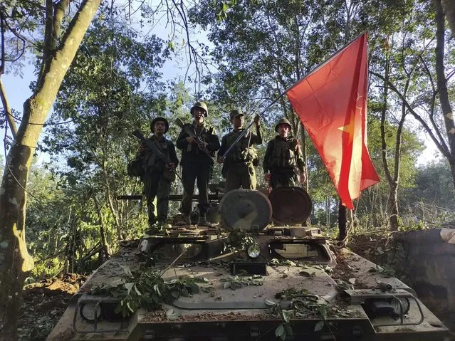 Members of the Myanmar National Democratic Alliance Army hold the group's flag as they pose for a photograph on a captured army armored vehicle in Myanmar, Saturday October 28, 2023. The leader of Myanmar’s army-installed government said the military will carry out counter-attacks against a powerful alliance of ethnic armed groups that has seized towns near the Chinese border in the country’s northeastern and northern regions, state-run media reported Friday Nov. 3, 2023. (“The Kokang” online media via AP Photo)