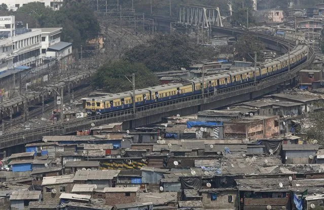 A suburban train passes through a slum area in Mumbai, India, February 17, 2016. (Photo by Shailesh Andrade/Reuters)