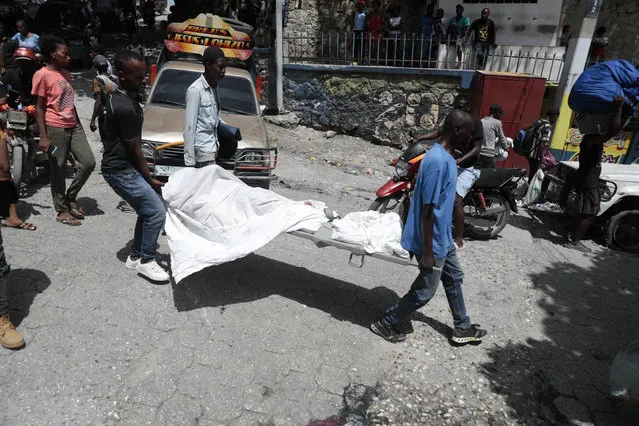 Morgue workers carry a body to an ambulance during gang violence in the Carrefour-Feuilles district of Port-au-Prince, Haiti, Tuesday, August 15, 2023. (Photo by Odelyn Joseph/AP Photo)
