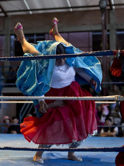 Cholita wrestler Natalia la Pepita, 19, lifts her trainer Reyna Torrez, 29, as they compete in the ring in El Alto, Bolivia, Monday, January 21, 2019. “You need a lot of bravery, strength and training to make a good fight. We fall and we hurt, but that doesn't matter because the public has fun”, said fighter in training Natalia Pepita, whose real name is Noelia Gonzalez. (Photo by Juan Karita/AP Photo)