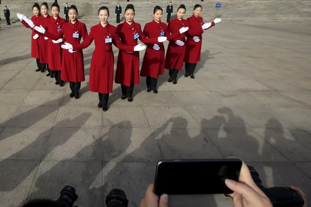 Hotel guides pose for pictures outside the Great Hall of the People during the opening session of the National People's Congress (NPC) in Beijing, China, March 5, 2016. (Photo by Aly Song/Reuters)
