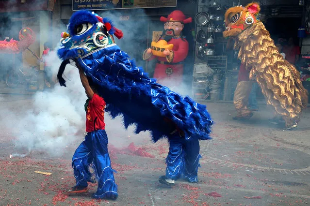 Revellers perform a lion dance amidst exploding firecrackers during Chinese Lunar New Year celebrations in Manila's Chinatown, Philippines January 28, 2017. (Photo by Ezra Acayan/Reuters)